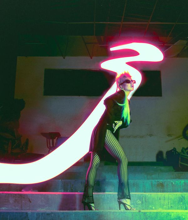 Woman performing a light, dynamic cardio movement in a bright, modern studio.